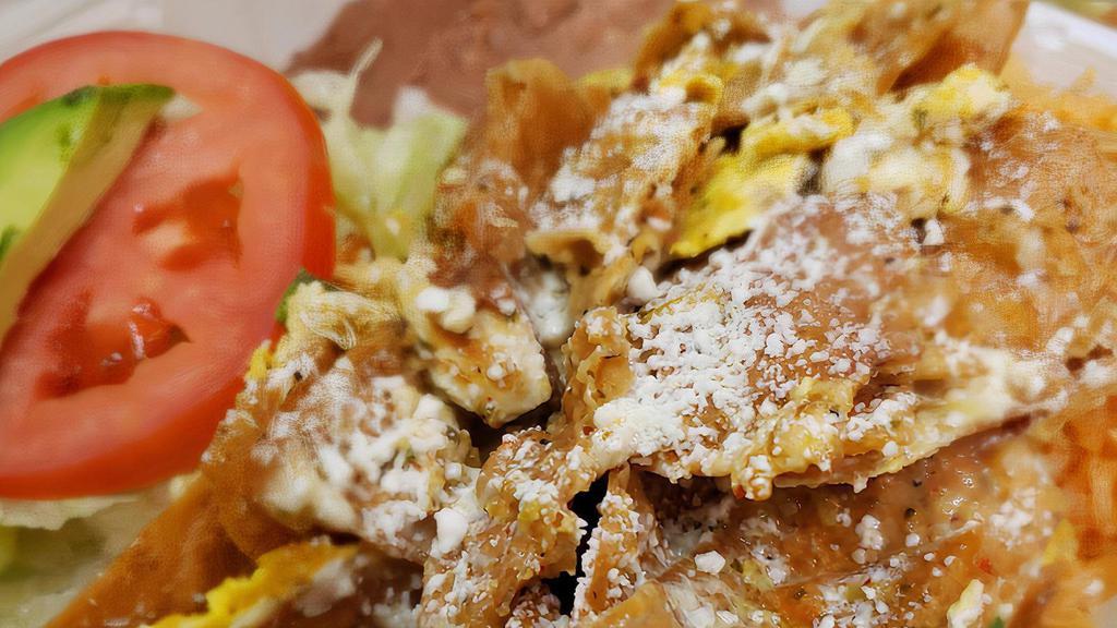 CHILAQUILES · Homemade tortilla chips cooked with eggs and tomato salsa; topped with cheese. Served with Spanish rice and refried beans.