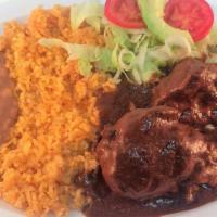  MOLE · Two chicken pieces prepared with special chile and spices, rice, refried beans, and handmade...