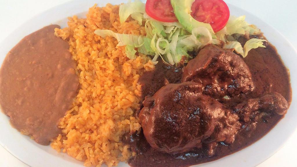  MOLE · Two chicken pieces prepared with special chile and spices, rice, refried beans, and handmade tortillas.