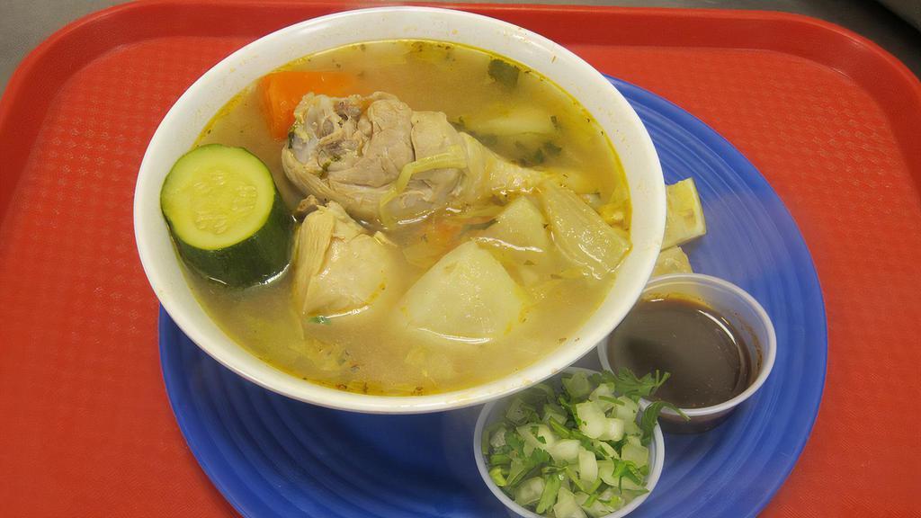 CALDO DE POLLO · Chicken soup cooked with carrots, potatoes, and zucchini; served with lime slices, a side of chopped onions, and salsa.