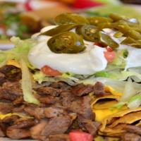 Supreme · Corn tortilla chips, topped with refried beans, melted nacho cheese, sour cream, jalapeños, ...