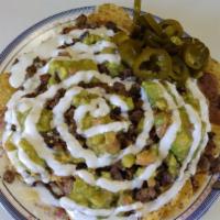 Super Nachos · Your choice of meat, refried beans topped with cheese, guacamole & sour cream.