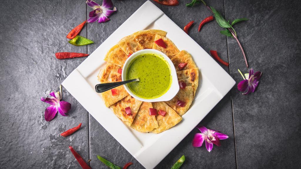 Roti with green curry · Pan-fried roti (asian pita bread) served with green curry dipping sauce, garnished with diced bell peppers