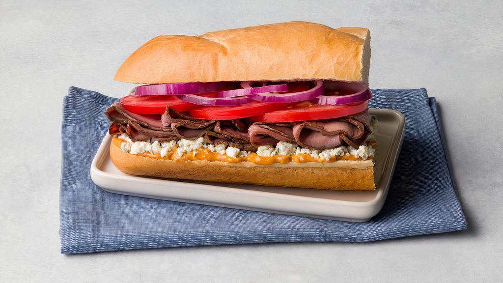 Chipotle Blue Roast Beef · London broil roast beef, blue cheese, tomatoes, red onion, chipotle gourmaise on French roll.