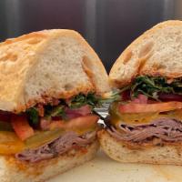 Roast Beef with Walnut Romesco · Roast beef, arugula, tomatoes, red onions, pickles with cheddar cheese and romesco spread on...