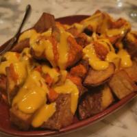 Patatas Bravas · Cubed, fried potatoes with almond romesco and garlic paprika aioli.