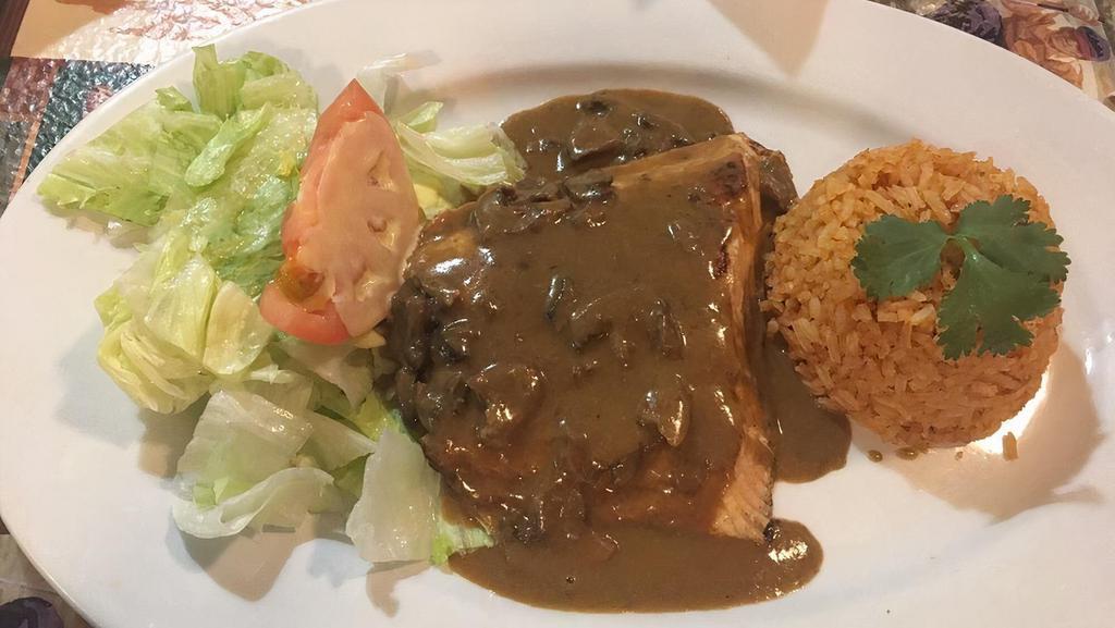 Salmon in Mushroom Chipotle · Grilled salmon covered in mushroom cream with hints of chipotle. Served with rice and house salad. Served with rice, beans, and salad .