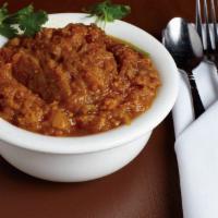 Baingan Bhartha · An eggplant specialty baked over open flame, mashed, and then sautéed with onions, garlic, g...