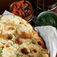 Naan · Leavened bread baked in a tandoor oven and topped with butter.