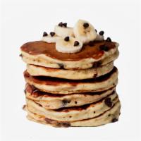 Banana Chocolate Chip Pancakes · Two large chocolate chip banana pancakes served with syrup.