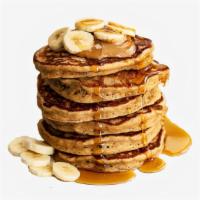 Peanut Butter Banana Pancakes · Two large peanut butter and banana pancakes served with syrup.