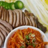 Bossam · Boiled pork belly with radish kimchi and cabbage.