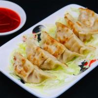 Pot Stickers (6 Pieces) · Pork pot stickers served with red vinegar on the side.