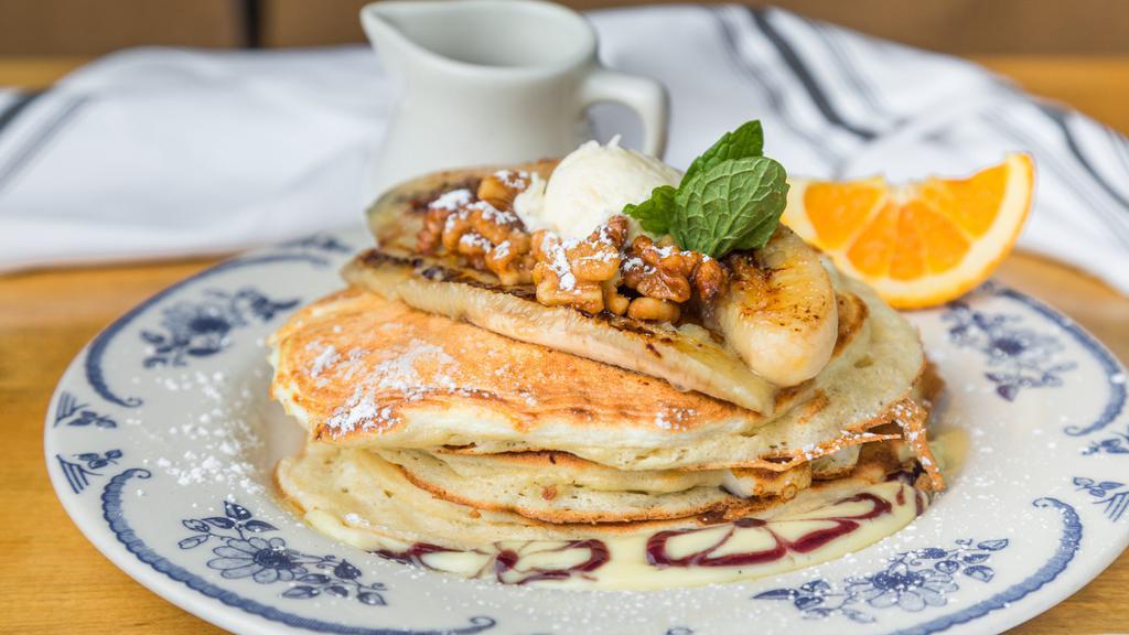 Banana Souffle Pancake · Vanilla curd, candied walnut, grilled banana and maple syrup.