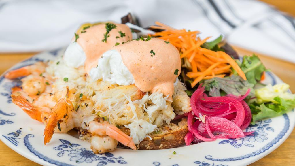 Baja California Benedict · Dungeness crab meat, thyme garlic shrimp, roasted jalapeno & bell pepper hollandaise, pickled red onion, avocado, and grilled miche.