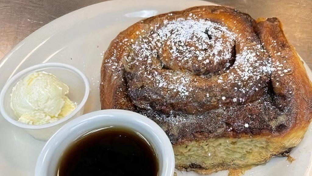 Cinnamon Roll French Toast · Our giant cinnamon roll baked fresh daily in our own oven, dipped in egg batter and grilled, sprinkled with powdered sugar and cinnamon. Served with two eggs any style and bacon or sausage.