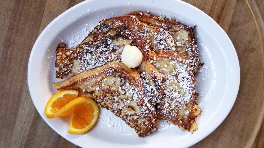 French Toast · Sourdough, orange zest-cinnamon egg batter, powdered sugar, whipped butter, served with maple syrup.