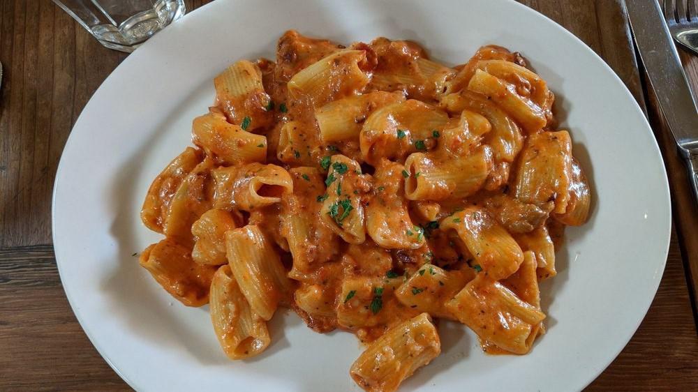 Rigatoni alla Vodka · Homemade pasta tubes, tossed with shallots, applewood smoked bacon, parsley, and a vodka, tomato cream sauce.