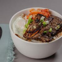 Teriyaki Beef Bowl · A bowl filled with teriyaki beef over steamed rice, with kimchi, scallions, and fried egg.
