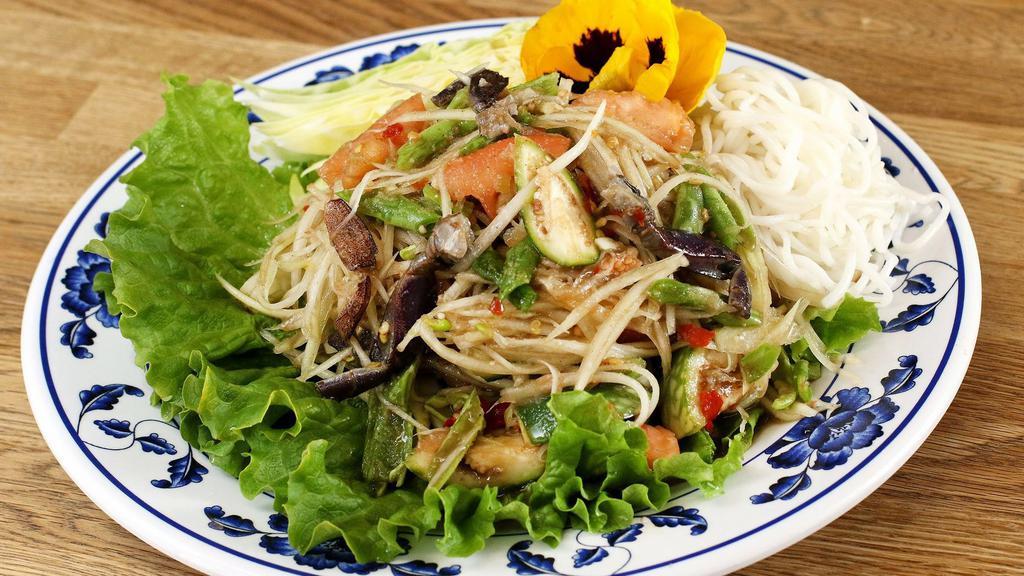 Loas Papaya Salad · Shredded green papaya with spicy dressing, fresh chilli, garlic, lime juice, long bean, anchovy and slated crab. With vermicelli noodle.