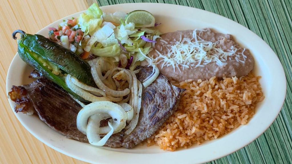 Carne Asada Plate · Grilled Carne Asada topped with grilled onions and jalapeños. Served with rice, refried beans and handmade corn tortillas.