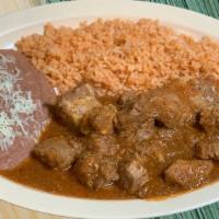 Costillas · Spicy Pork ribs in a homemade red sauce served with rice, refried beans and handmade tortill...