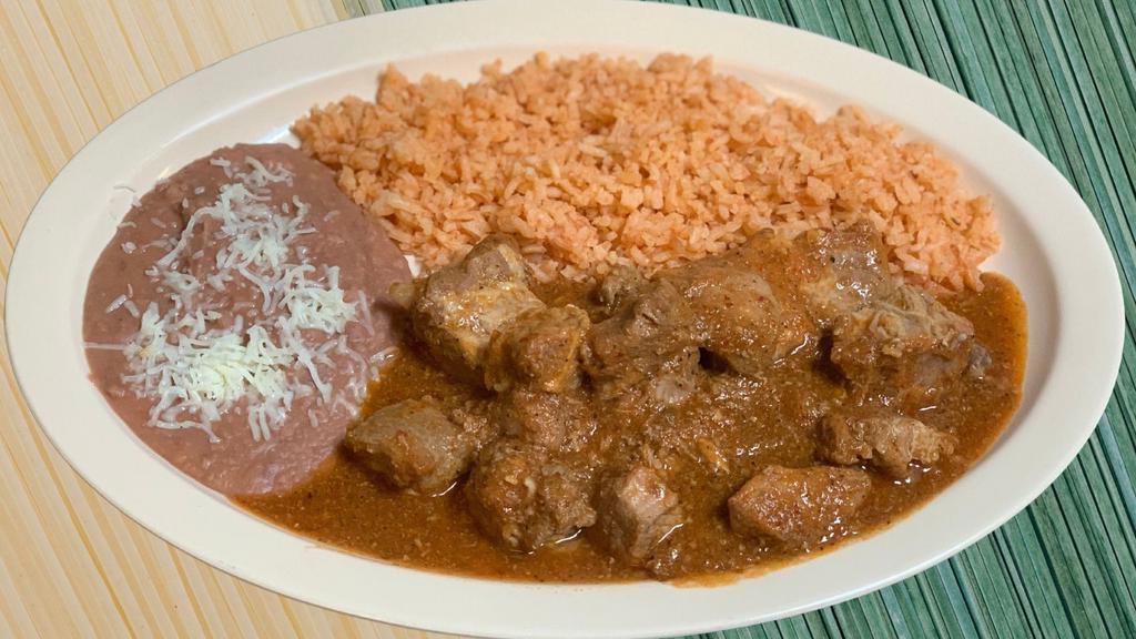 Costillas · Spicy Pork ribs in a homemade red sauce served with rice, refried beans and handmade tortillas.