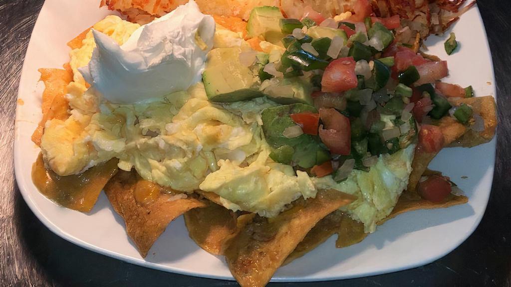 Chilaquiles · Tortilla chips tossed in a spicy red sauce and cheddar cheese. two eggs cooked any style, topped with homemade salsa,  avocado, and sour cream.