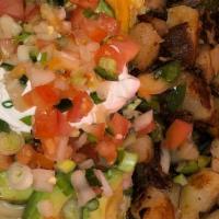 Tostada Scramble · Two crispy corn tortillas topped with chili and two eggs scrambled with chorizo, green onion...