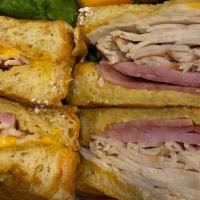 Monte Cristo · Turkey, ham and cheese on battered Texas toast. Topped with powdered sugar.