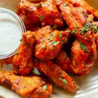 Buffalo Chicken Wings · A dozen wings tossed in our signature house made buffalo sauce