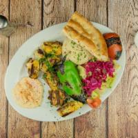 Chicken Kebab · Marinated chicken breast skewer cooked on a grill served with rice, salad, hummus, and Turki...