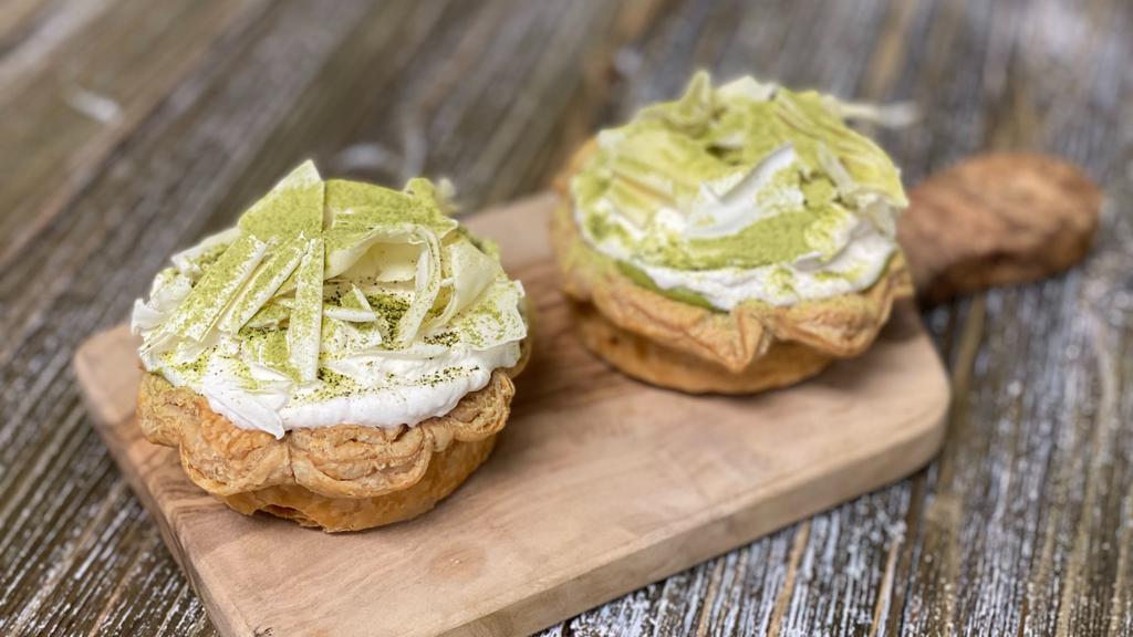 Set of 2 Matcha Cream Pie · Two pieces. Silky Matcha pastry cream (made with 100% Japanese ceremonial grade matcha powder) and house-made salted caramel in a flaky crust, topped w/ lightly-sweetened whipped cream and garnished with white chocolate shavings and Matcha powder dusting.