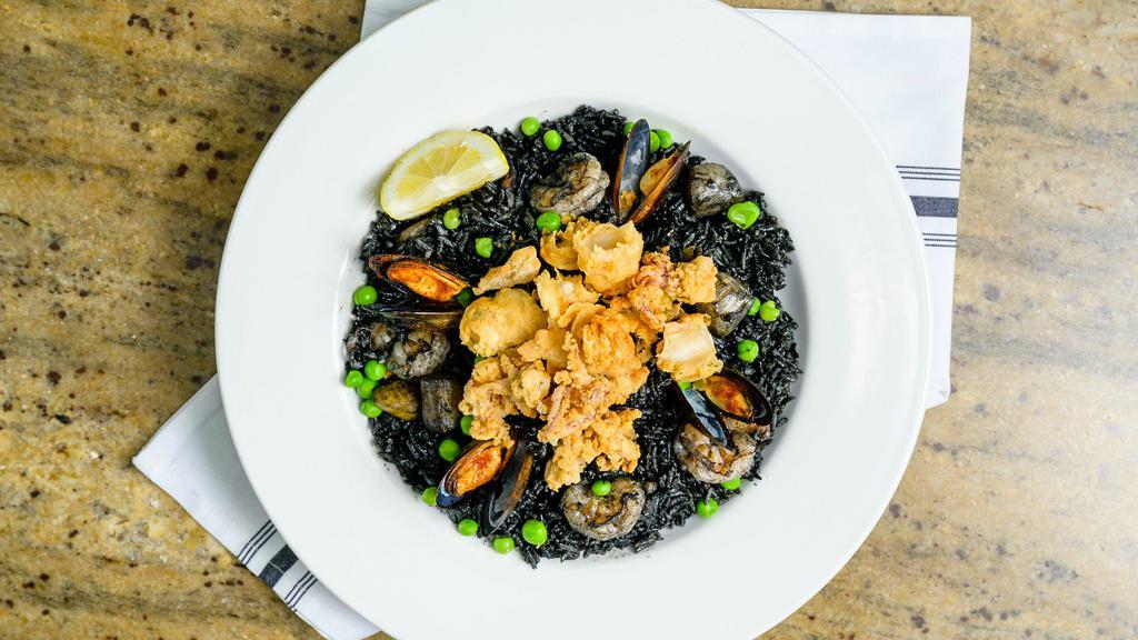 Seafood Black Rice · Good for three people. Our signature black fried rice with shrimps, scallops,
snow crab meat and special ingredients topped with
crispy calamares, mussels and green peas.
