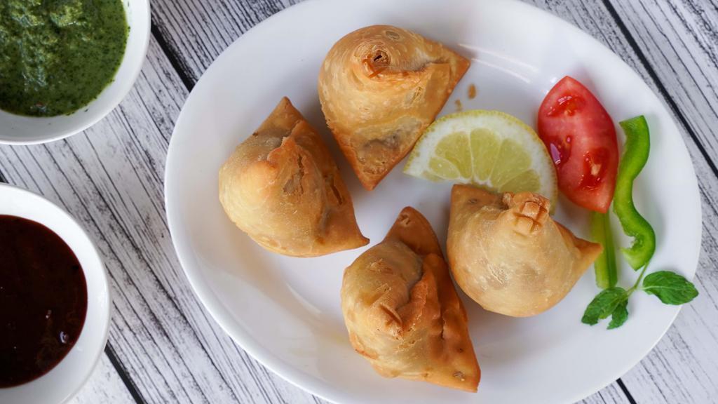 Samosa (2 pieces) · Veggie turnover, stuffed with potatoes, green peas, herbs, and spices, served with chutney.