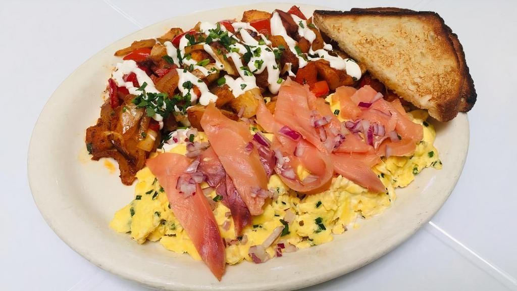 New York Scramble · Eggs scrambled with sour cream and chives, topped with smoked salmon and diced red onion served with breakfast potatoes and toast