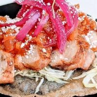 Pollo Panucho · Crispy handmade corn tortilla, stuffed with black bean puree, topped with cabbage, pickled o...