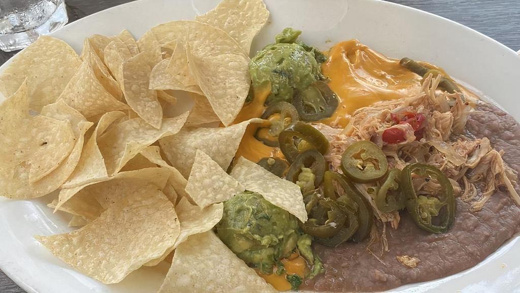 Nachos · Tortilla chips, nacho cheese, refried beans, guacamole, sour cream and jalapenos