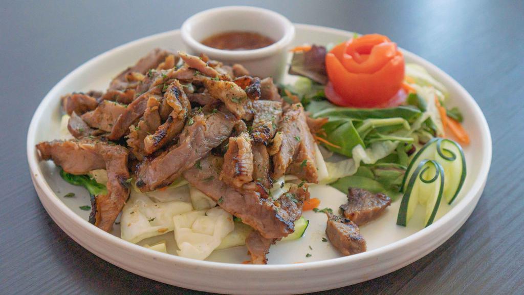Bangkok BBQ Pork · Char-broiled pork marinated with chopped garlic coriander and thai herbs served with homemade sweet chili sauce and sautéed vegetables and garlic.