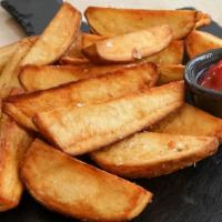 Potato Wedges · A mound of golden, crispy, incredibly addictive fries, fried potato wedges.