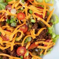 Steak Taco Salad · Delectable steak salad featuring romaine, rice, beans, fresh salsa, guacamole, cheeses and s...