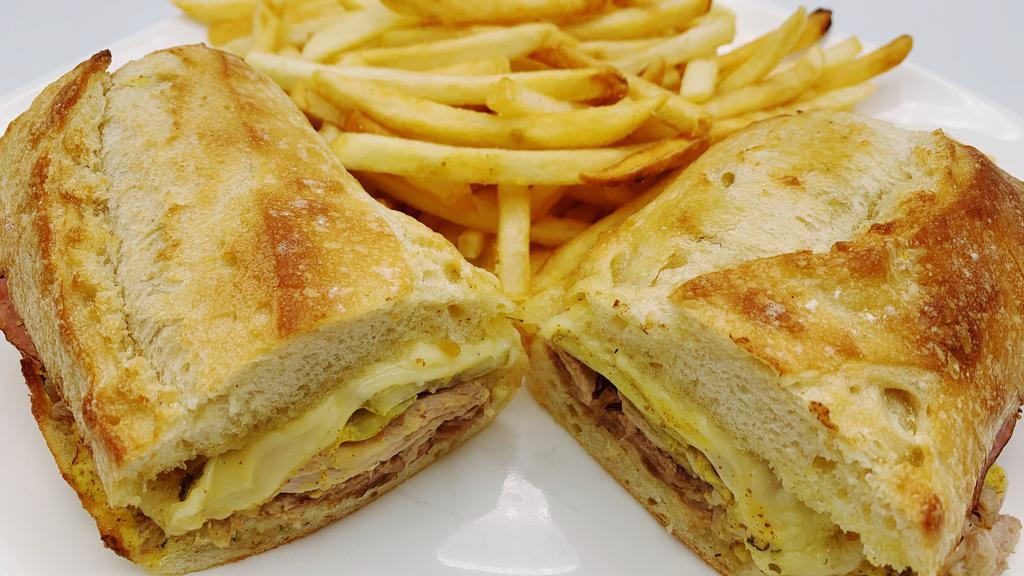 Cuban · Grilled marinated pork, grilled ham, pickles, spicy mustard and swiss cheese on baguette. Served with fries.