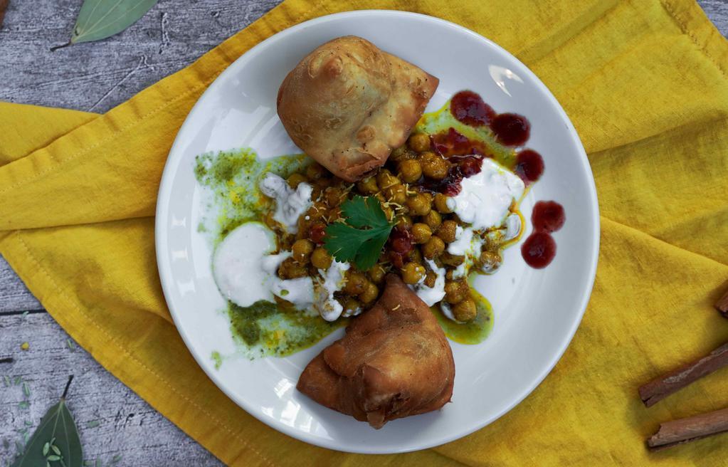 Samosa chaat · Deep fried pastry stuffed with potatoes served on the bed of garbanzo beans.