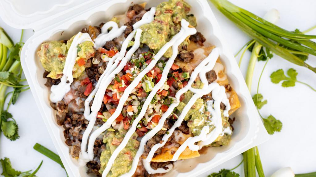 Super Nachos · Choice of meat, topped with beans, sour cream, pico de gallo, melted cheese, and guacamole.