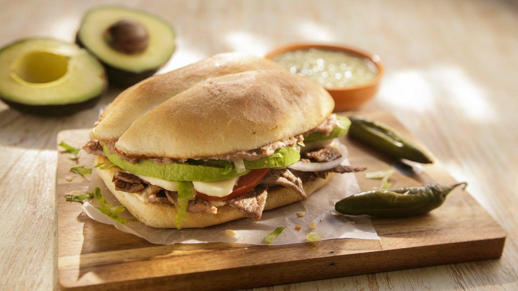 Torta · Choice of meat, topped with beans, tomatoes, onions, lettuce, avocado, queso fresco, and mayonnaise.