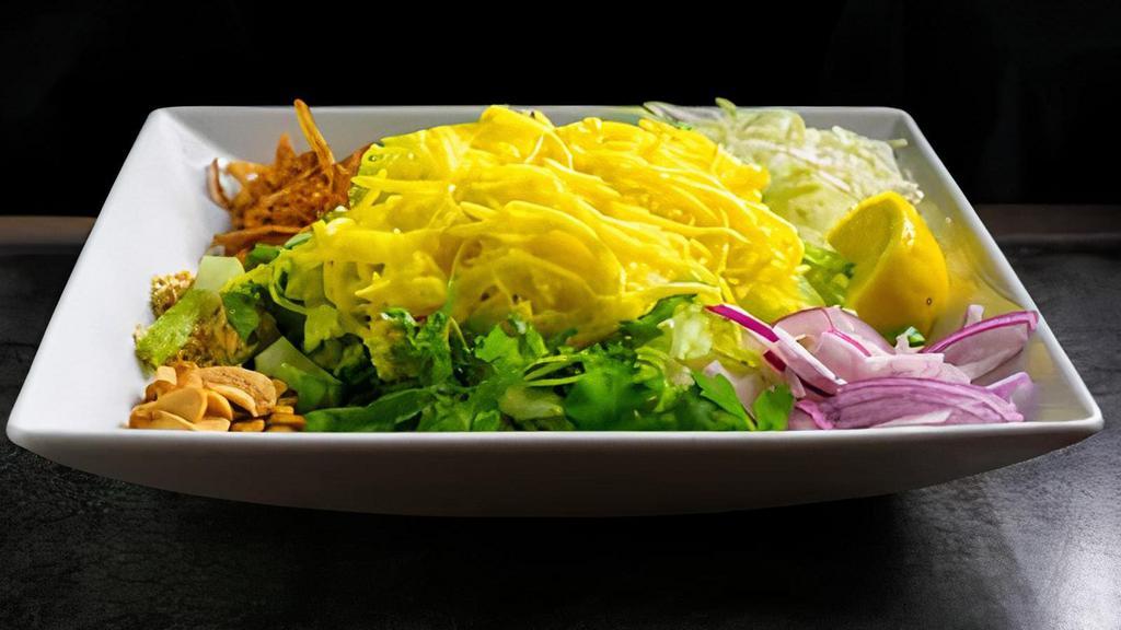 Mango Salad · Shredded pickled mangoes served with fried onions, fried garlic, cabbage, red onions, yellow bean powder, cucumbers, cilantro and dried shrimp.