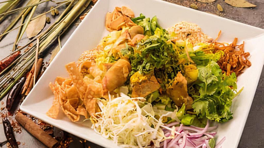 Samosa Salad · Salad with vegetarian samosas, cabbage, onions, cilantro, cucumbers, yellow bean powder, tamarind sauce, mint, sesame seeds with crushed red chili added to taste.