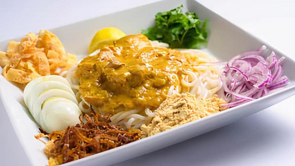 (C) Nan Gyi Dok · Rice noodles topped with coconut chicken sauce, yellow bean powder, cilantro and fried onion. Topped with hard boiled egg and crispy wontons.
