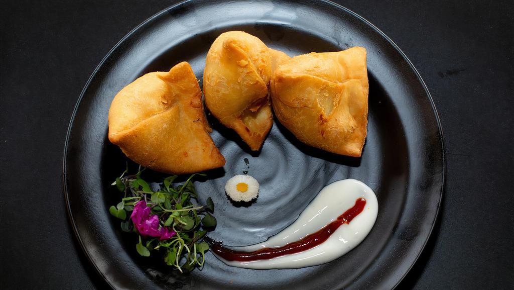 Veg Samosa (2 pcs) · Crispy vegetable turnovers with flavored potato and peas filling, served with chutneys. Allergy Indicators: Gluten