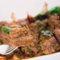 Lamb Pepper Fry · Boneless lamb cubes marinated in special spices, deep fried, and tossed with peppers & onions